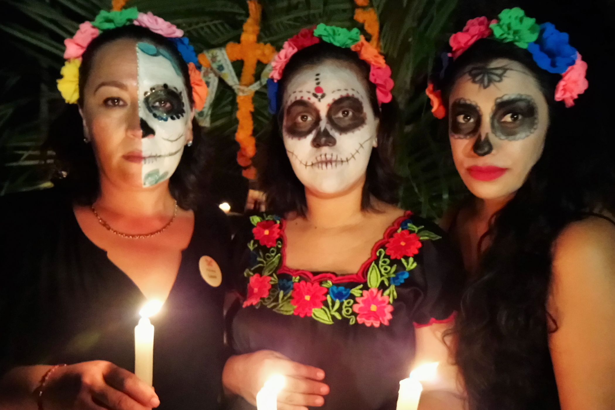 A Group Of Women Wearing Masks And Holding Candles